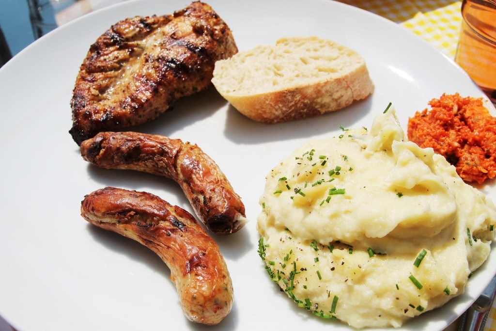 Rostbratwürstchen und mariniertes Hähnchen an Tomate-Basilikum-Grillbutter mit einem Hauch Limette, dazu Baguette und Erdpfelkäse